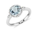 An aquamarine engagement ring is framed by a halo of pavé diamonds and set in leaf-shaped milgrained white gold