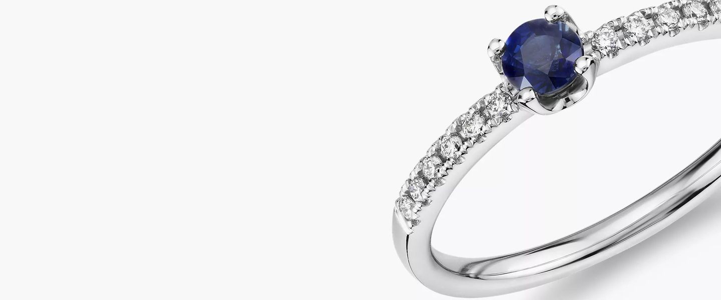 A September birthstone stacking ring showcasing petite sapphire center stone with diamond sidestone accents set in white gold