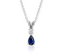 A birthstone pendant with pear-shaped blue sapphire center hanging from round diamond that's set with a white gold double bail setting on a matching chain