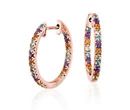 A pair of multi-gemstone hoops featuring citrine, peridot, blue topaz, and amethysts adorning rose gold huggie earrings
