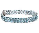 Three layers of oval cut blue topaz circle a birthstone bracelet set in sterling silver