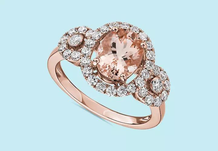 A morganite engagement ring framed by two brilliant cut diamonds detailed with diamond pave set in rose gold