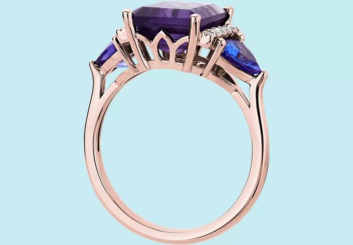 Pear shaped tanzanite side stones frame an amethyst engagement ring accented by diamond detail and rose gold