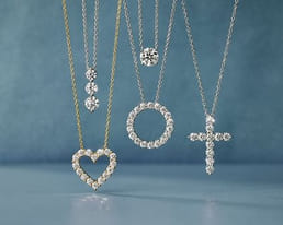 Four diamond necklaces with heart, circle, cross, and drop pendants
