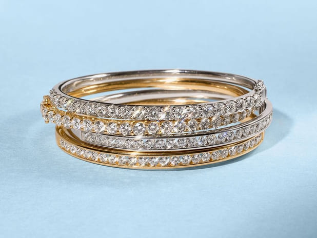 Stack of gold and silver diamond bracelets