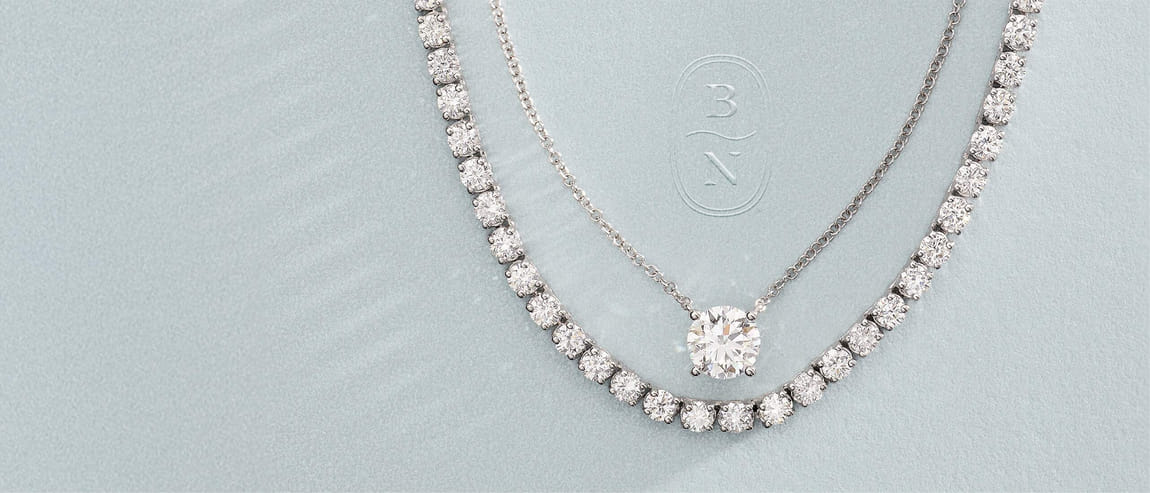 Diamond necklaces on textured background with BN logo.