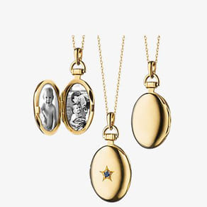 Gold lockets with star design and family photos inside on display.