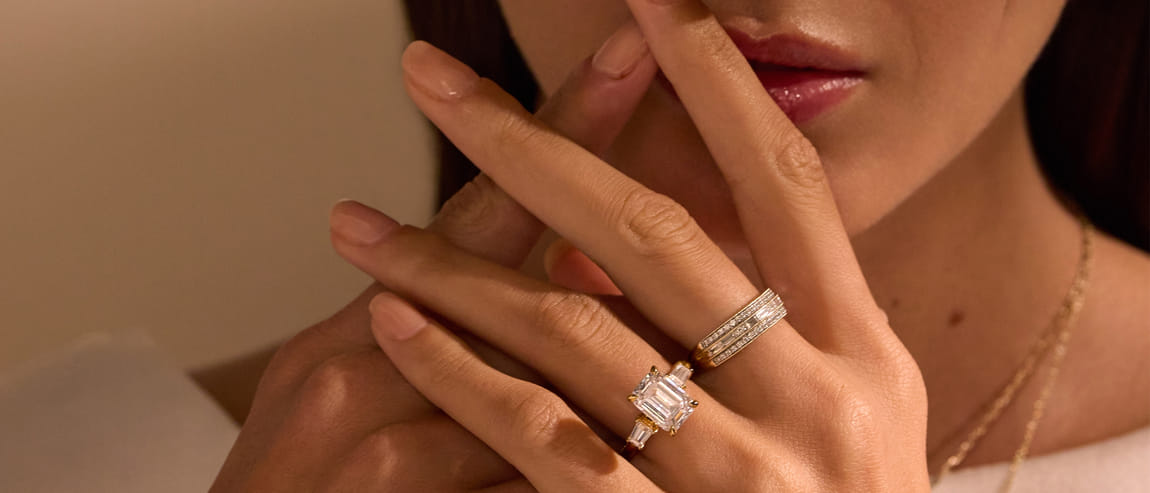 Woman's hand with two elegant rings and subtle makeup.