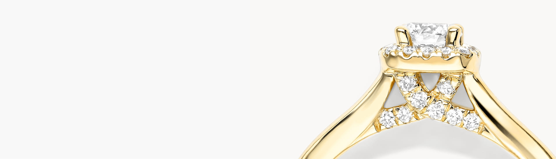 Gold engagement ring with diamond accents on the band and a central diamond solitaire.