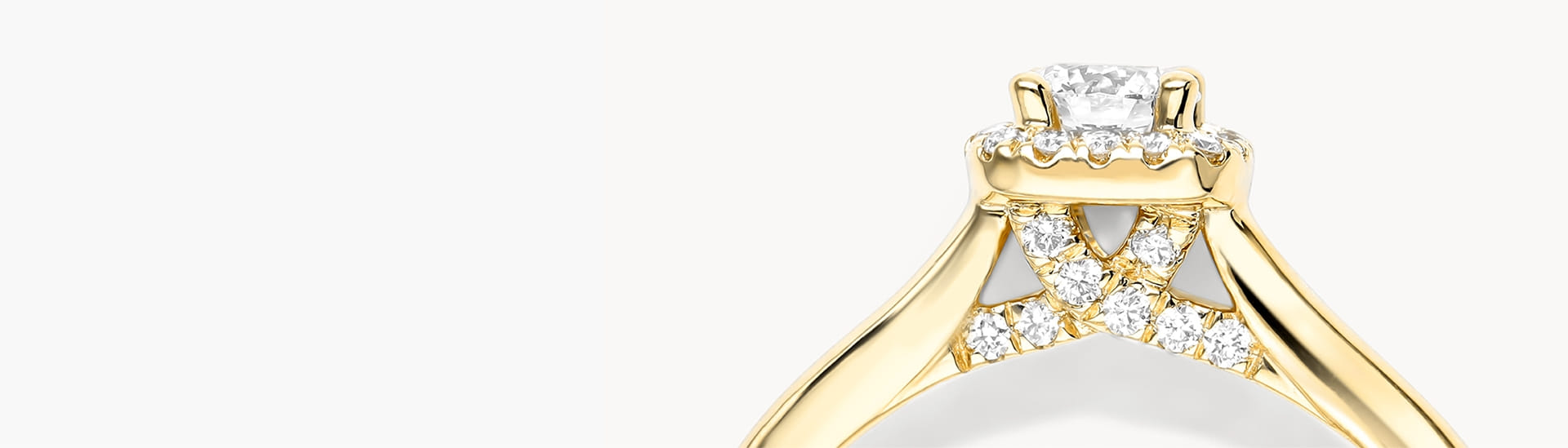 Gold engagement ring with diamond accents on the band and a central diamond solitaire.