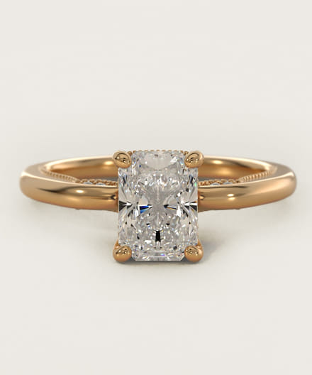 Gold engagement ring with a radiant cut diamond.