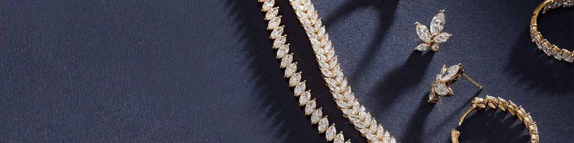 Elegant gold jewelry set with diamond accents on a dark background