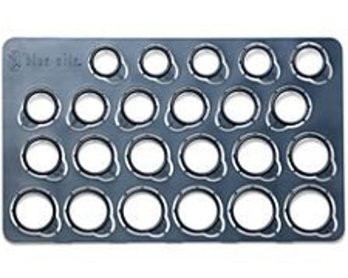 Ring size measuring tool with multiple circular slots on a flat surface.