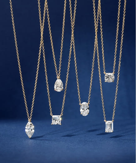 Gold necklaces with varied diamond shapes on a blue background.