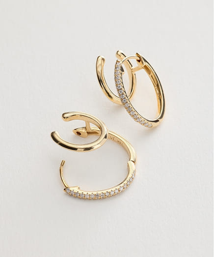 Golden hoop earrings with small diamonds on a white background.