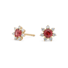 Gold stud earrings with red gems surrounded by small diamonds in a floral design.