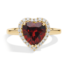 Gold ring with a heart-shaped red gemstone surrounded by small diamonds.
