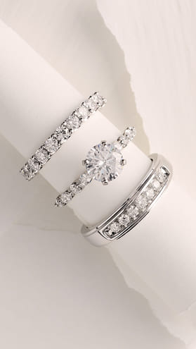 Three diamond rings with a central solitaire on a white background.