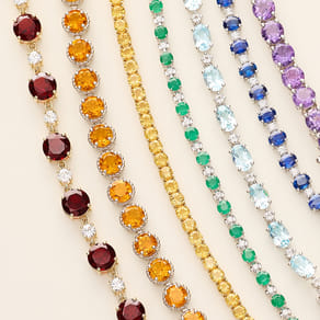 Colorful gemstone bracelets arranged in parallel rows on a soft background.