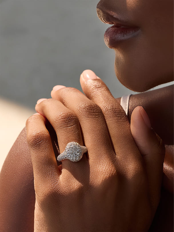 Hand with elegant diamond ring near the face in soft lighting. Hand with elegant diamond ring near the face in soft lighting.