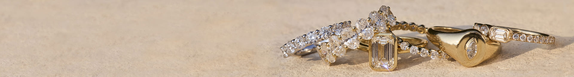 Collection of gold rings with diamonds and a heart-shaped diamond pendant necklace.